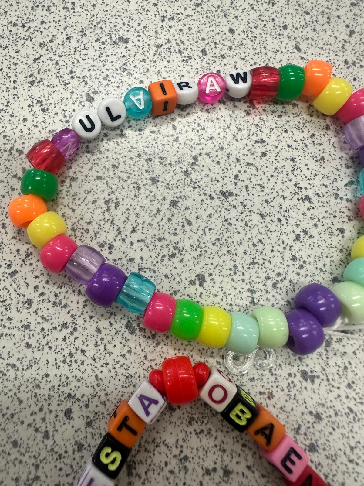 Colorful beaded necklace with letter beads spelling 'ULTRA' showcasing the creative outcomes