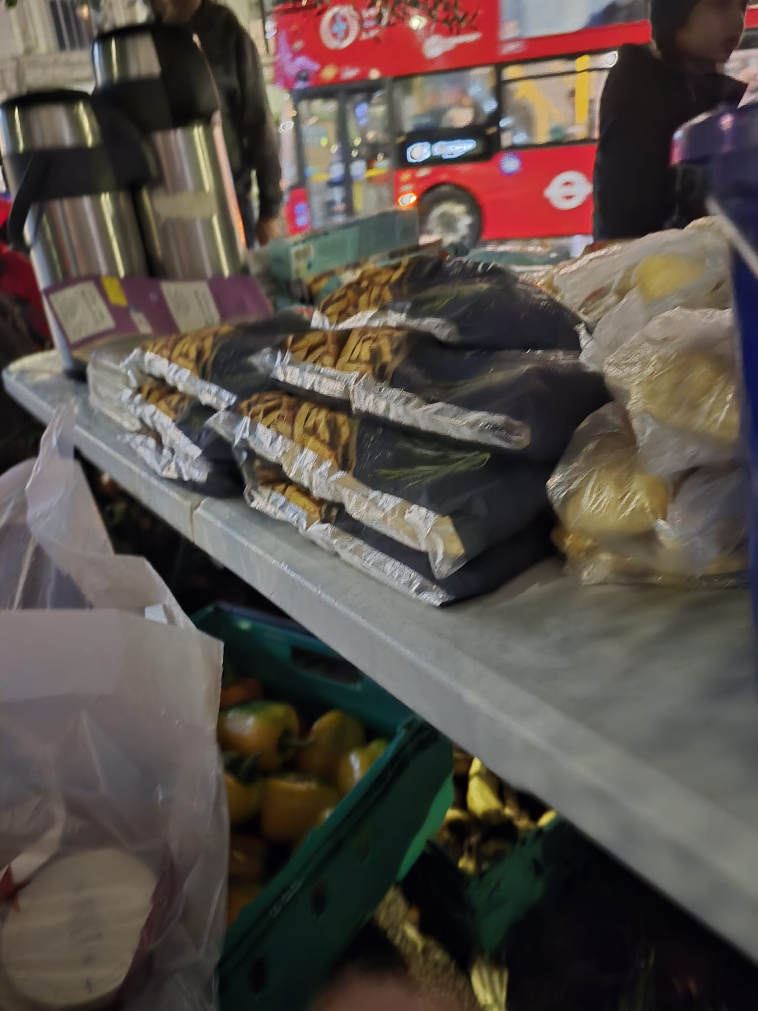 Street food distribution in London with red double-decker bus in background